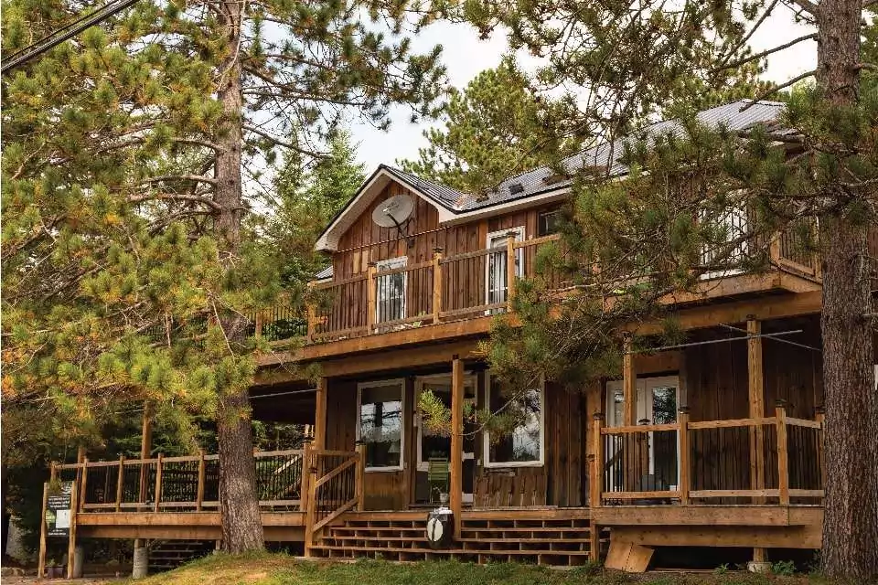 Bellwood Inn exterior picture showing the cabin among the forest, surrounding the wooden structure with evergreens