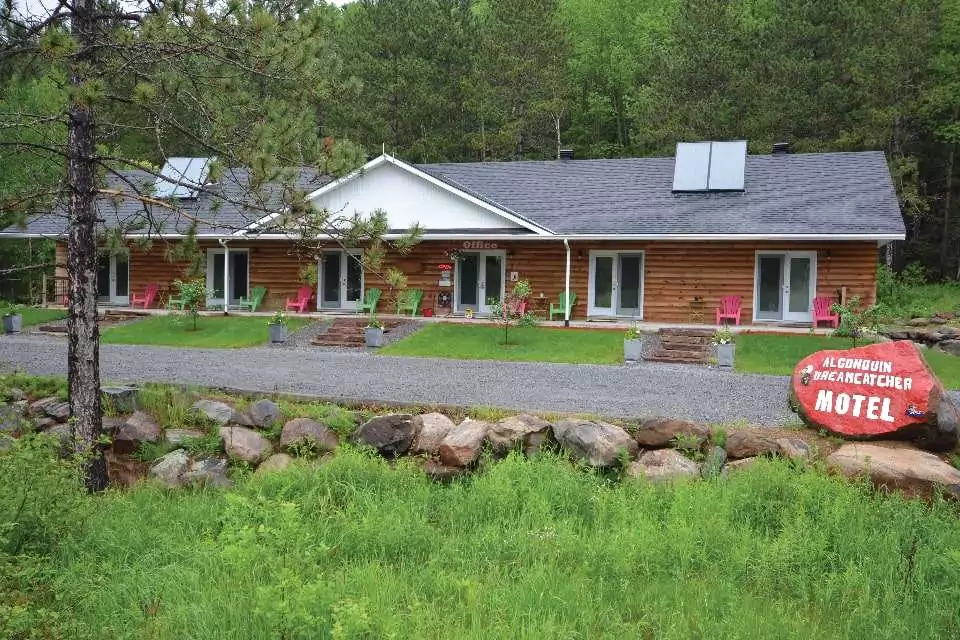 Dream Catcher Motel exterior photo showing the excellent location backed by forest and easy parking in the front