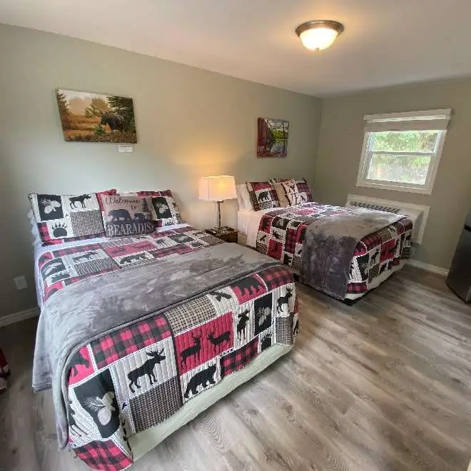 An image of a newly renovated motel room at the East Gate Motel showing two beds, image on the wall and sunlight coming through a window.