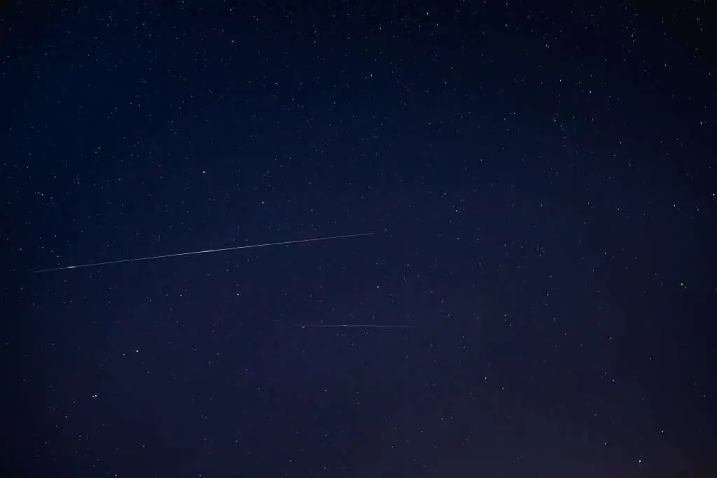 Two Meteoric Tracks In The Blue Night Starry Sky Background. Nat