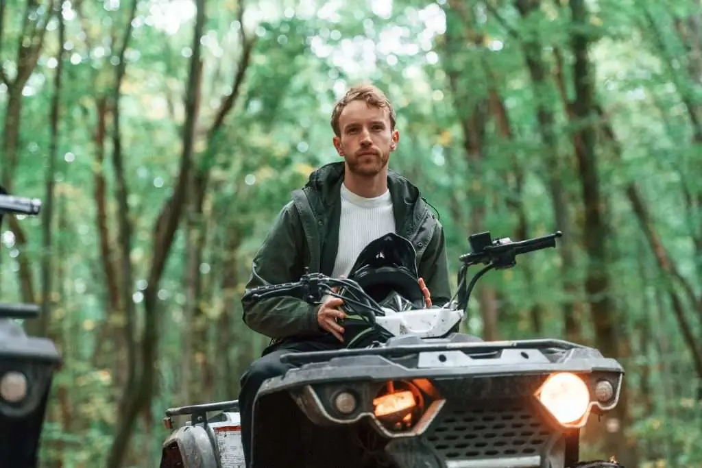 With safety helmet. TV driver is in the forest, having a ride at daytime