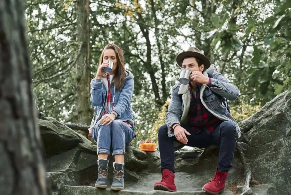 Backpackers drinking coffee or tea during hiking