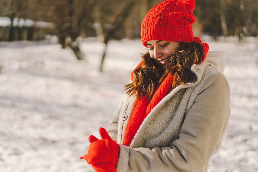 A beautiful woman in winter clothes is enjoying the winter.