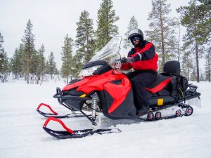 A Man on snowmobile in winter mountain