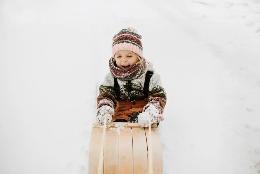 Canada, Ontario, Smiling girl on toboggan