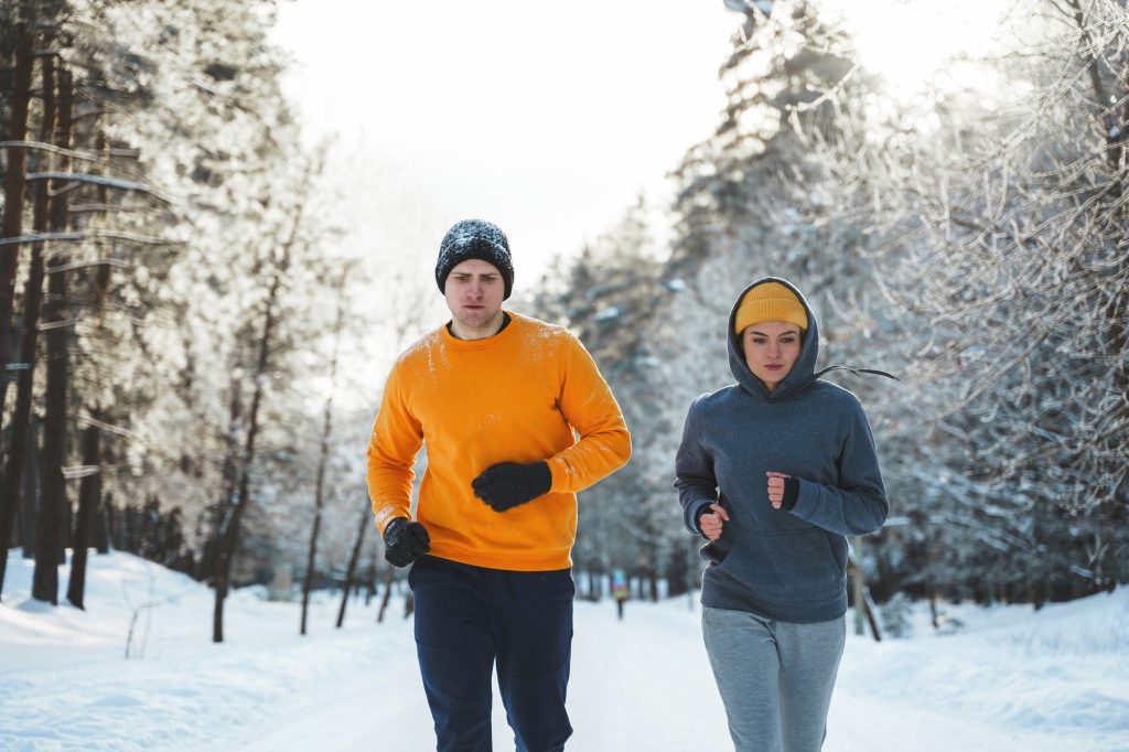 Sportive couple during winter jogging in city park