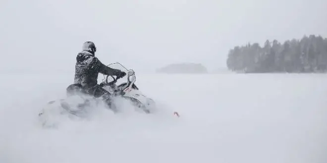 a man driving a snow bicycle in heavy snow