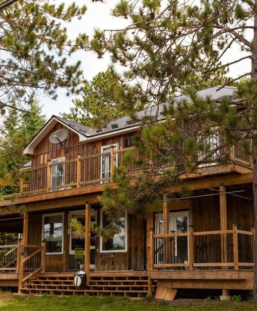 Bellwood Inn exterior picture showing the cabin among the forest, surrounding the wooden structure with evergreens