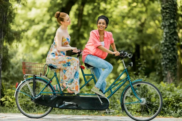 Young women riding on the tandem bicycle